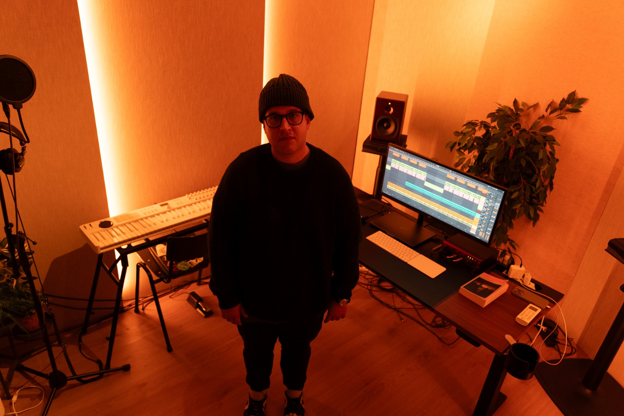 Naulé standing in his studio, bathed in orange light